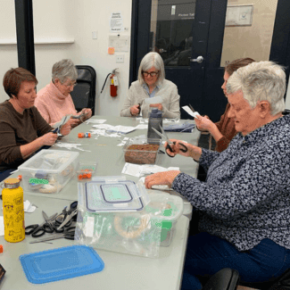 People at a table doing crafts.