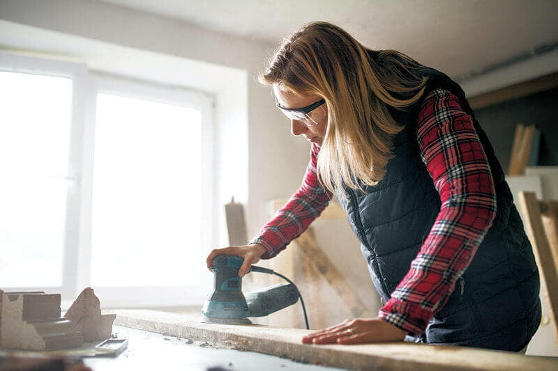 Person sanding a wooden board.